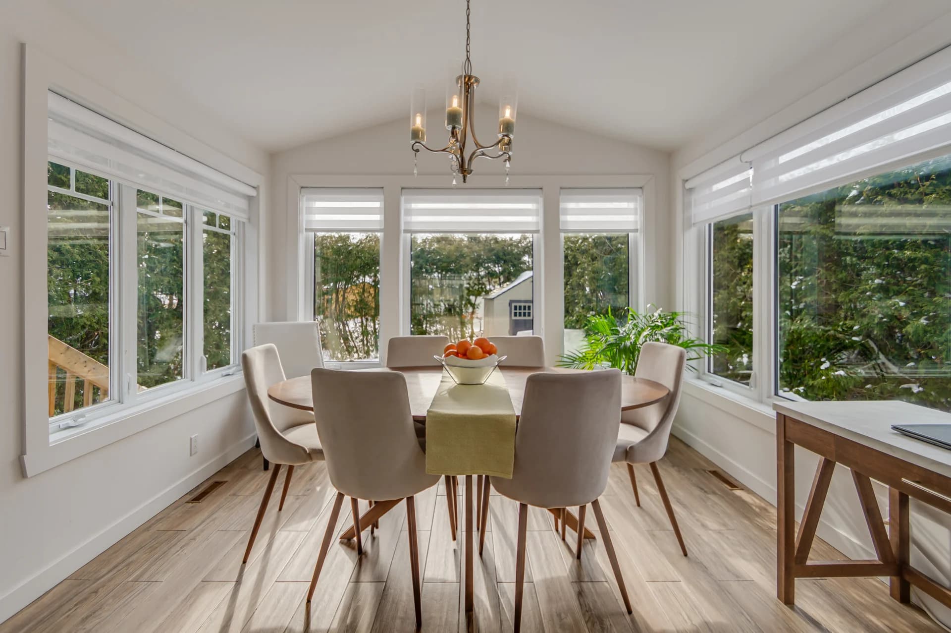 Salle à manger entourée de fenêtres donnant sur la verdure