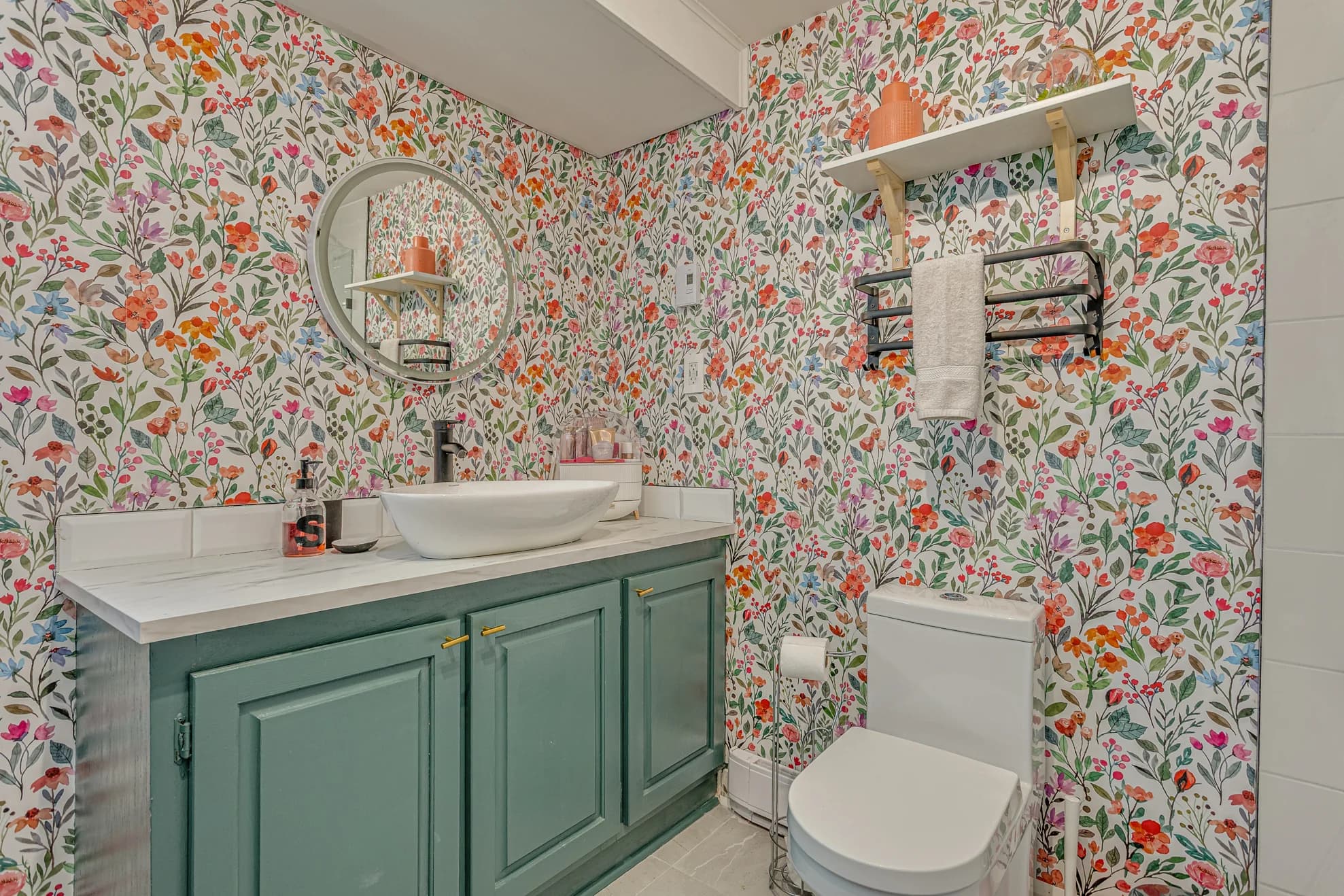 Salle d'eau avec vanité verte et papier peint floral