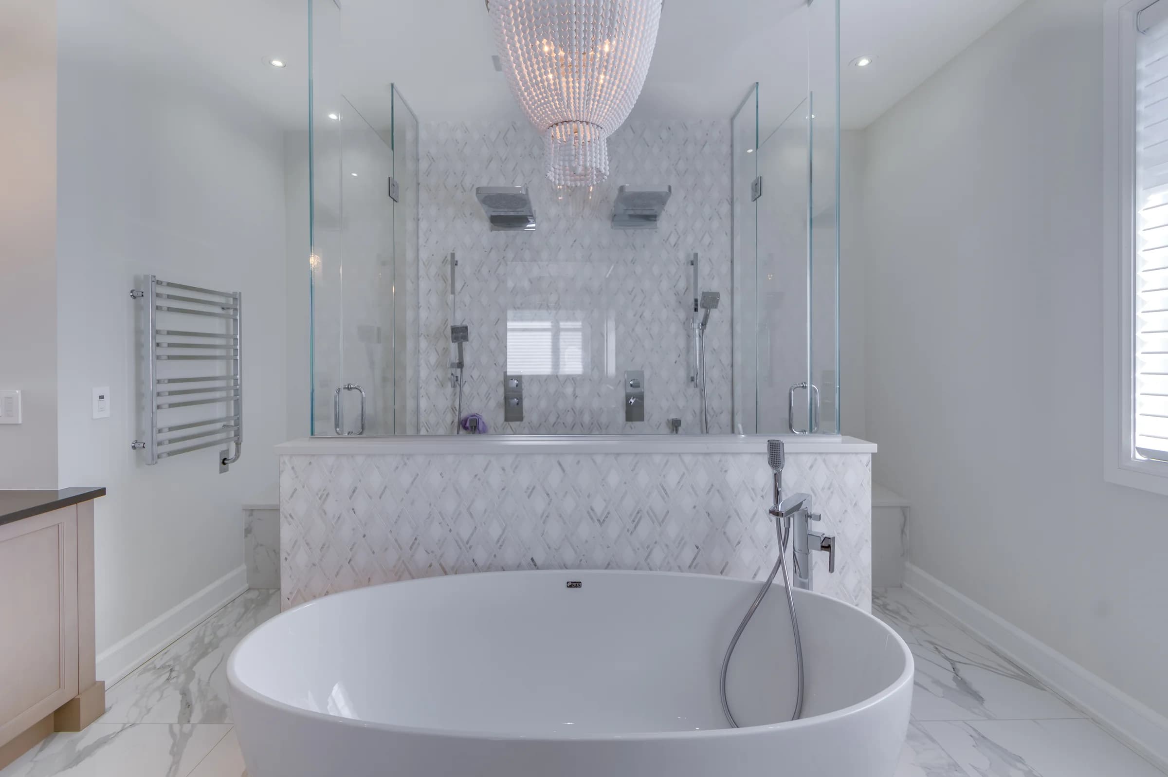 Salle de bain blanche avec baignoire ovale et grande douche vitrée